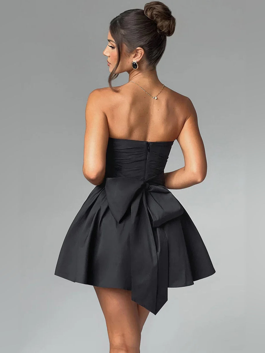 Black strapless mini A-line dress with ruched bodice and large bow at waist.