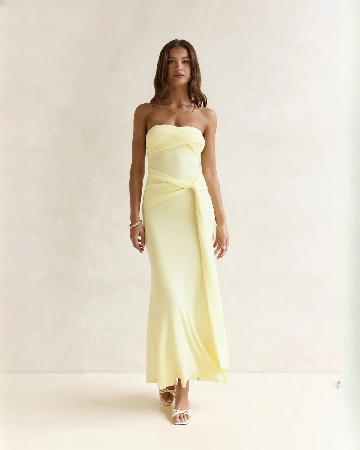 Light yellow strapless satin A-line maxi dress, tied waist sash, floor-length skirt