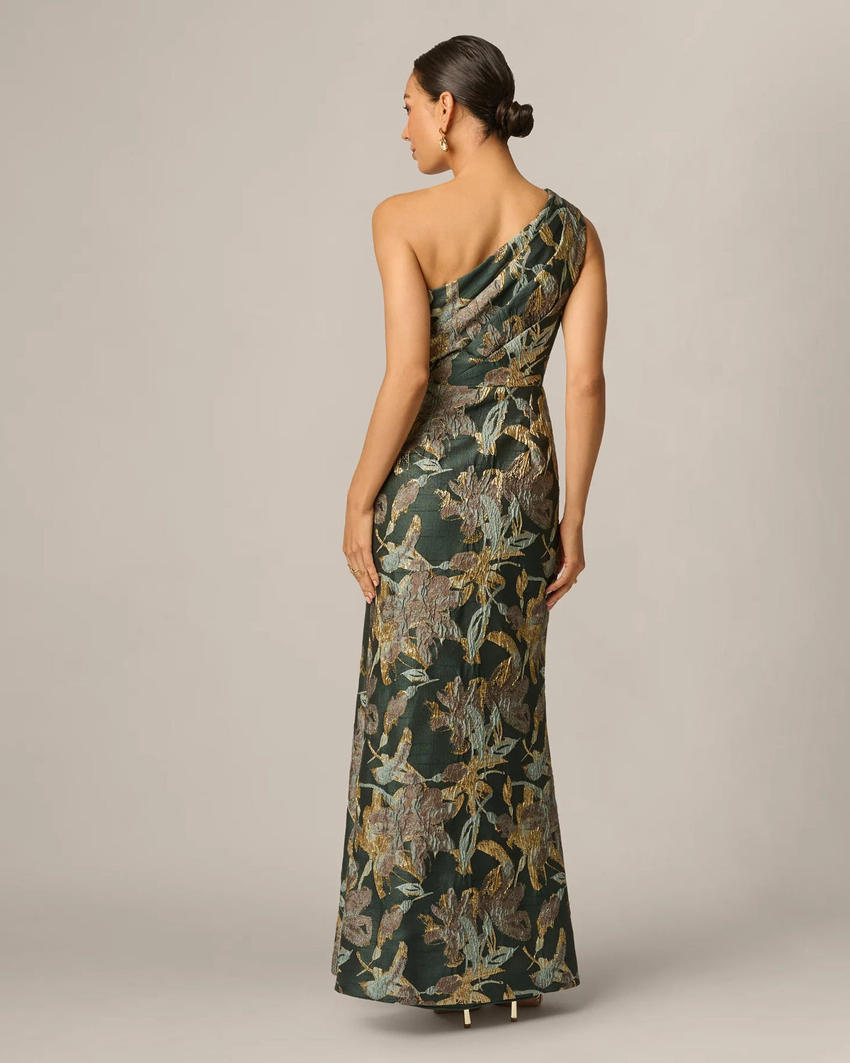 Back view of one-shoulder A-line maxi dress with dark green and gold botanical print