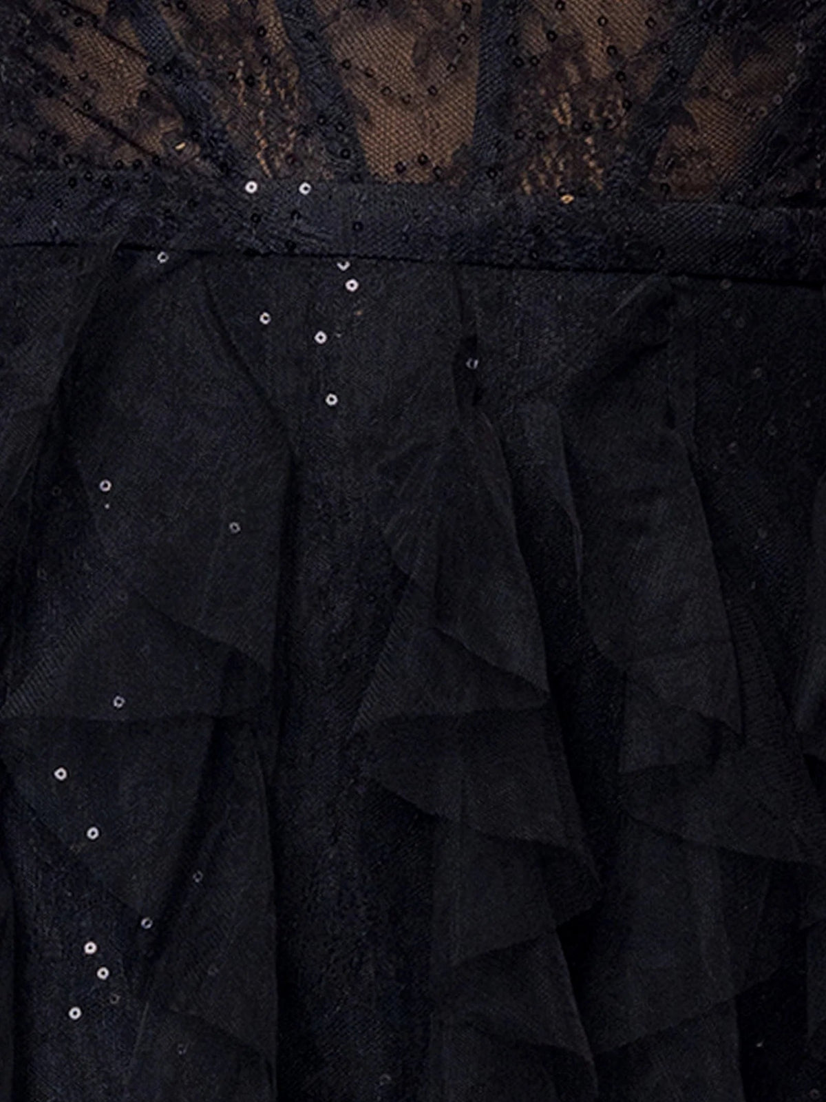 Close-up of black tiered tulle skirt with sequined detail and mesh overlay