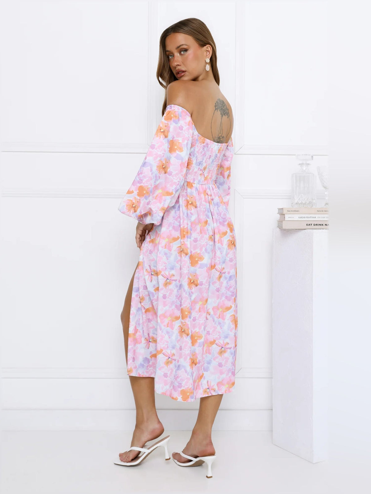 Back view of floral off-shoulder midi dress with puff sleeves and gathered bodice.