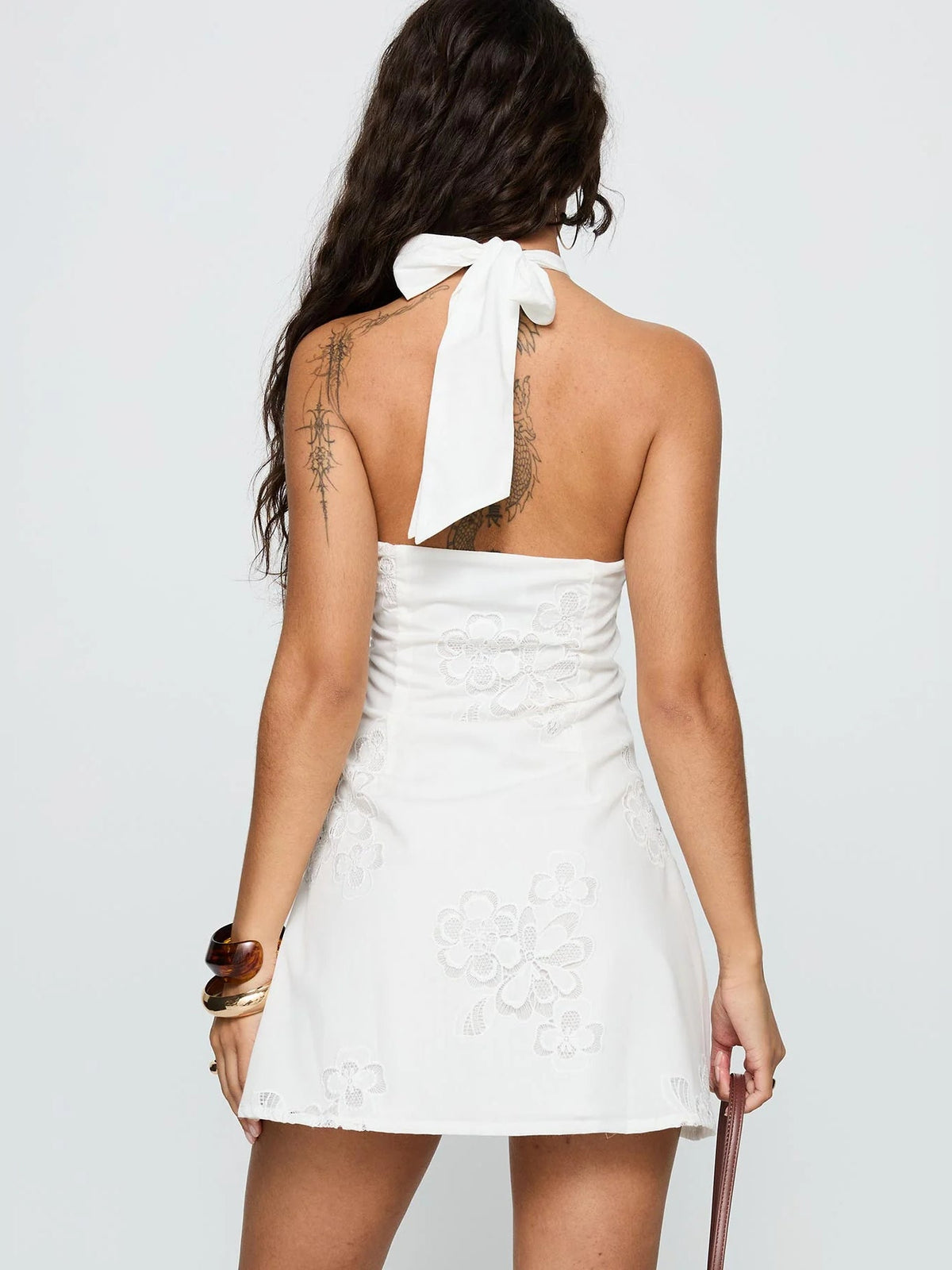 White halter neck mini dress back view with bow-tied halter strap and floral lace