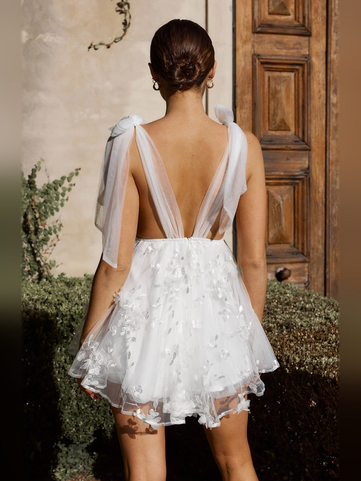 White mini homecoming dress open-back design with sheer bow ties, layered tulle skirt