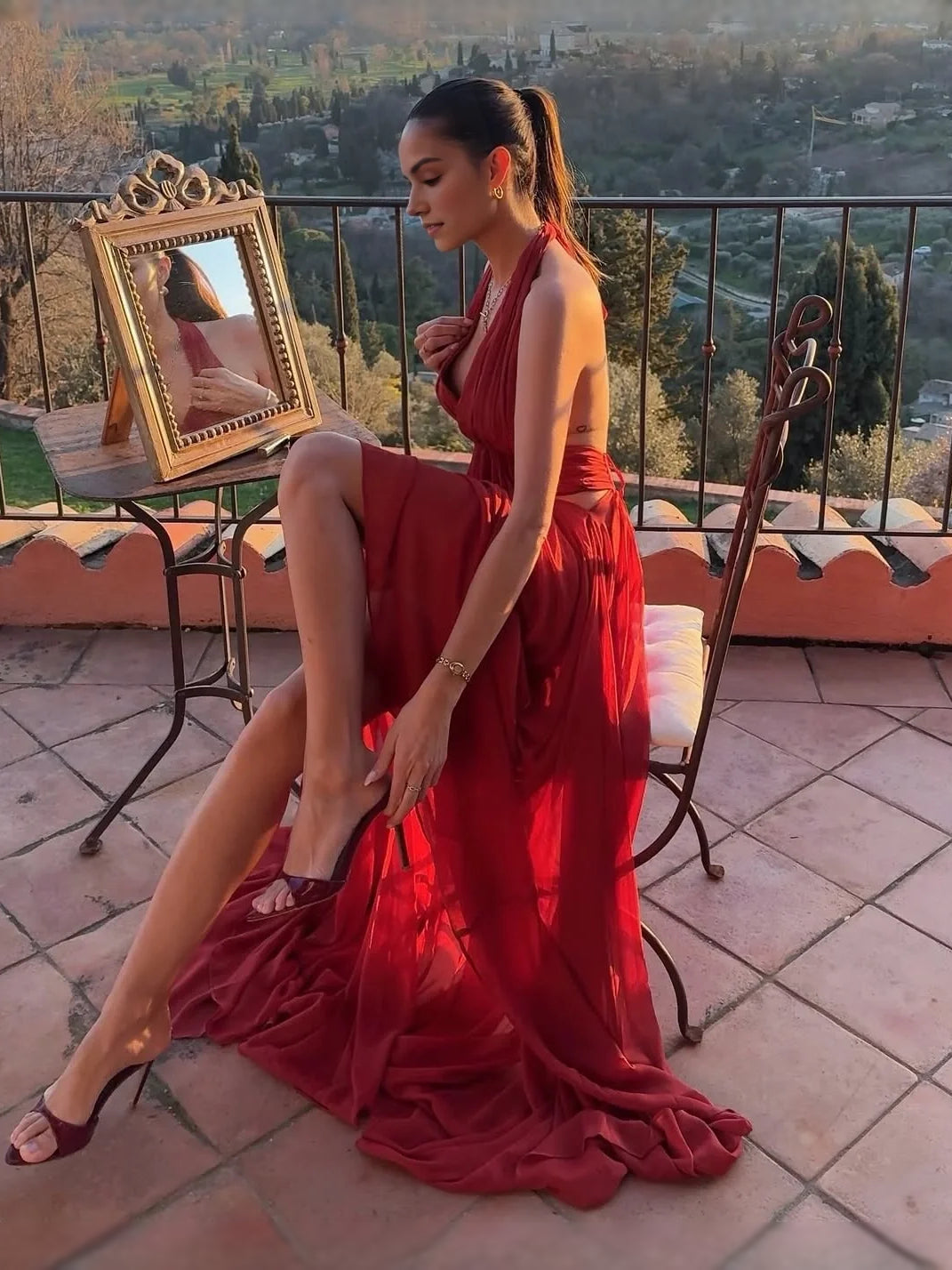 Red open-back maxi dress with halter straps and draped skirt