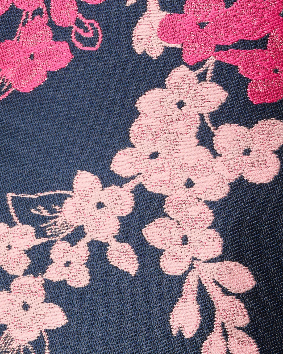Pink floral motif on navy textured fabric, close-up
