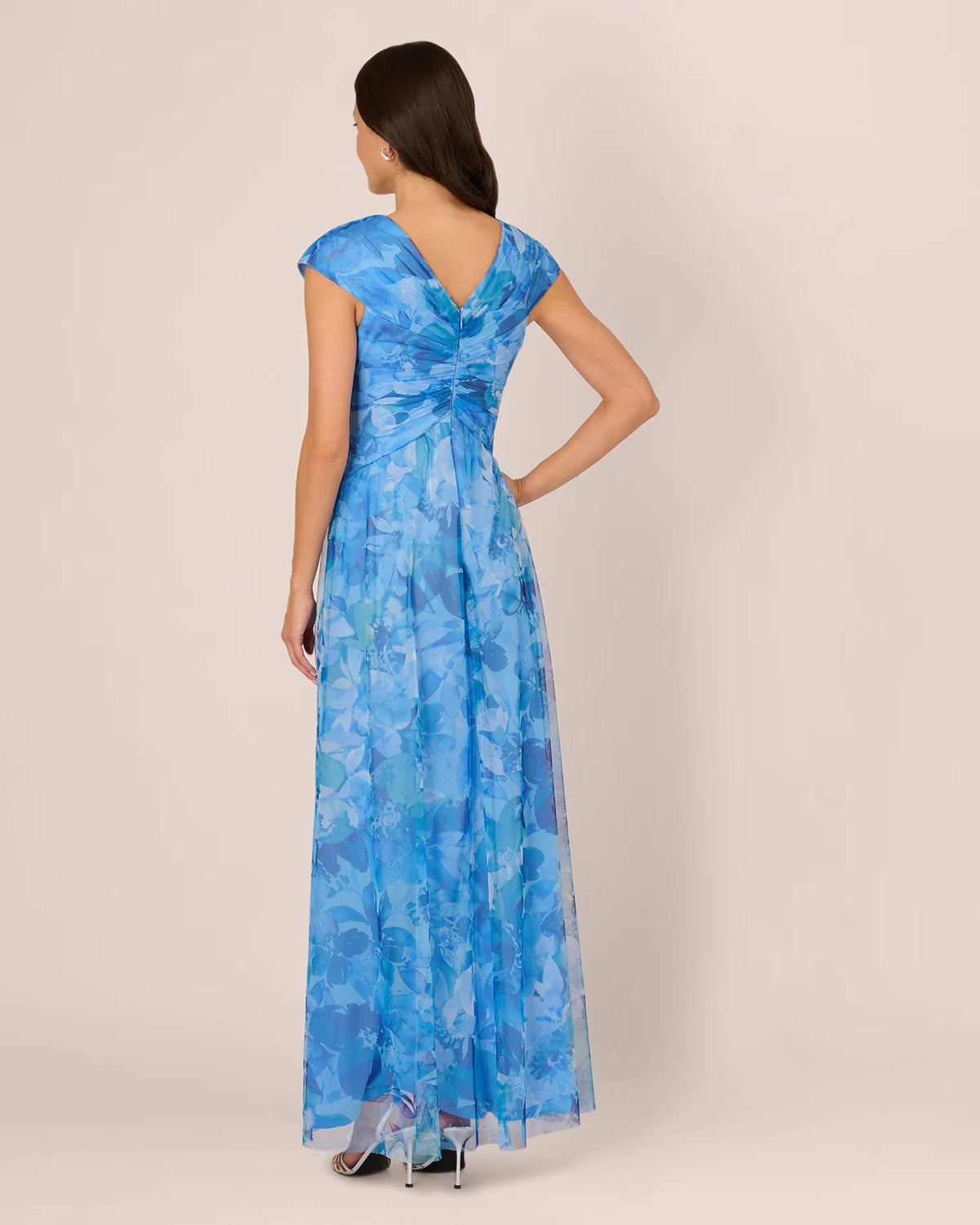Back view of blue floral A-line maxi dress with cap sleeves and center waist twist