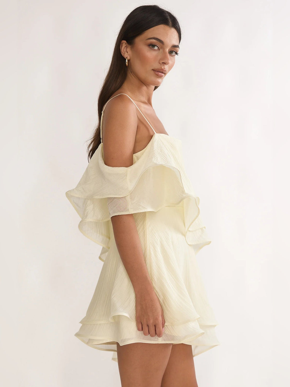 Cream mini dress side profile with tiered ruffles and thin spaghetti straps