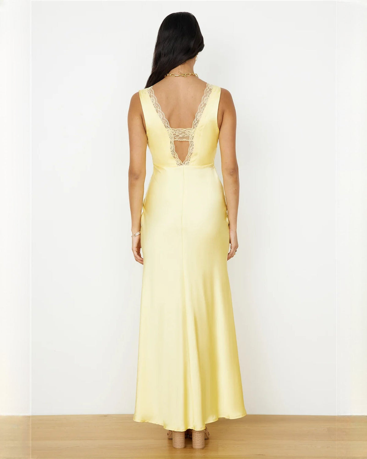 Light yellow satin A-line maxi dress back view with lace-trim shoulders and open neckline