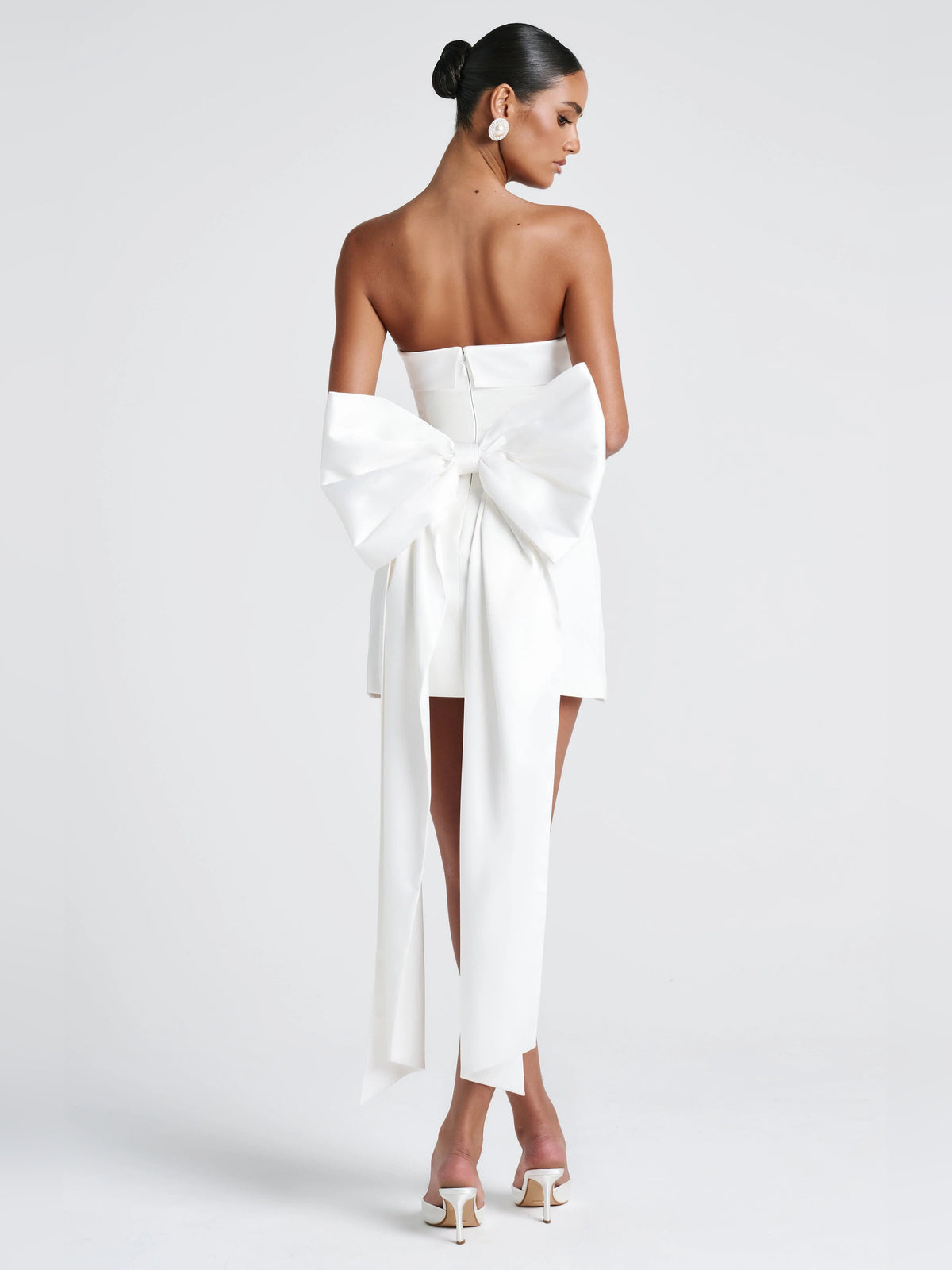 Ivory strapless mini dress with large centered bow and flowing ribbon ties