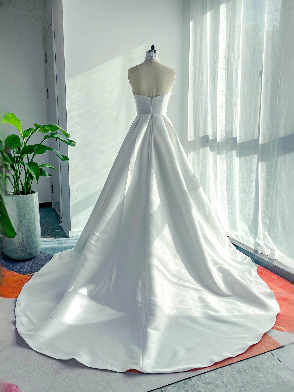 White strapless sweetheart A-line satin wedding dress with full skirt and long hem