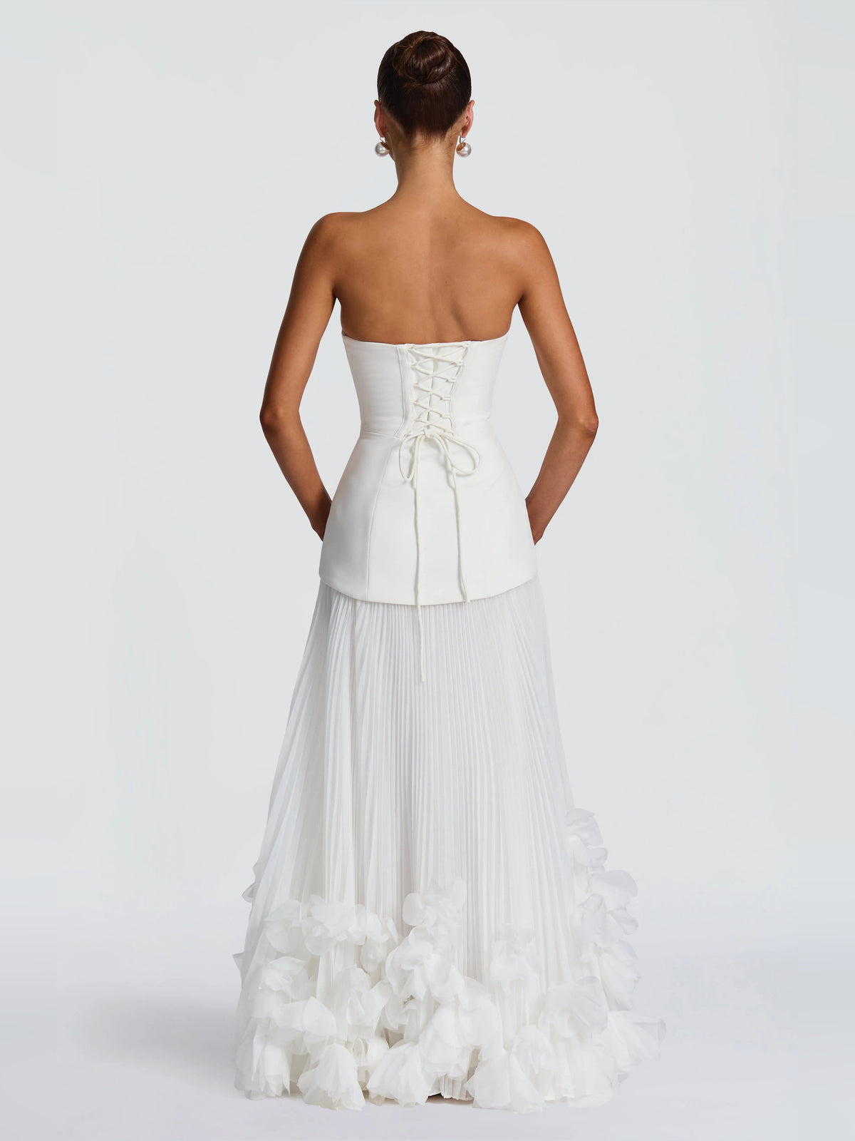 Back view of ivory strapless wedding dress with corset back detail and layered ruffle skirt