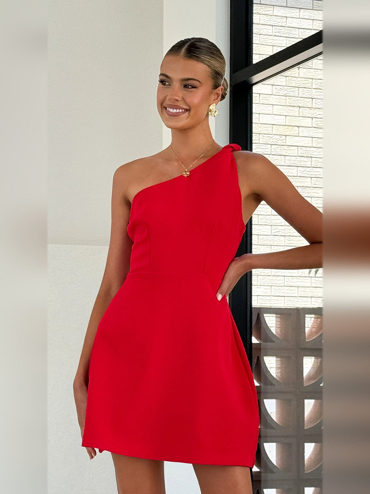 Red mini one-shoulder dress with structured neckline and side drape detail