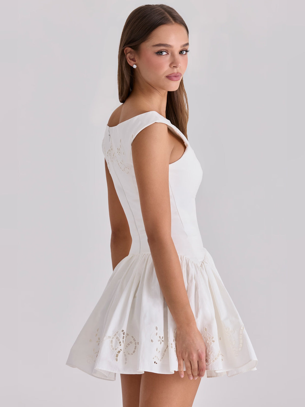 White sleeveless boat-neck mini dress, fitted bodice with embroidered eyelet skirt