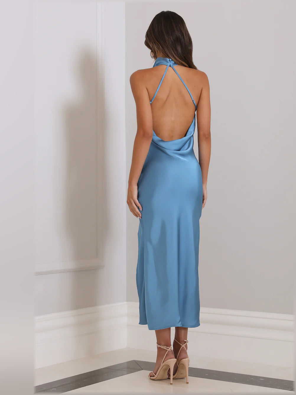 Back view of blue satin midi formal dress, halter tie back, open back, side slit
