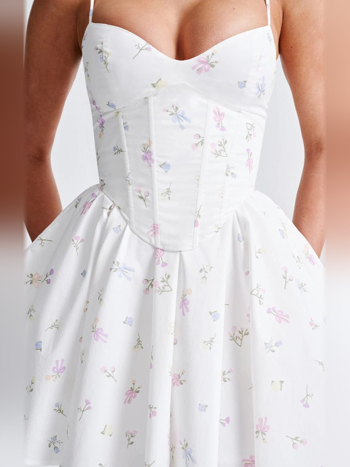 Close-up of white floral corset bodice with spaghetti straps and gathered skirt