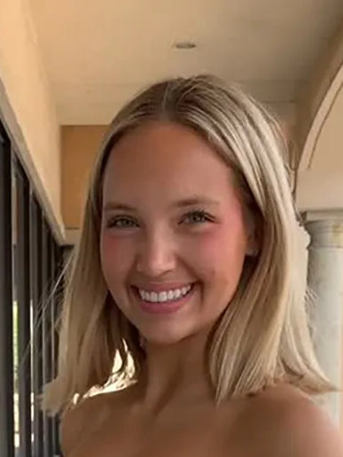 Smiling model with blonde hair; dress not visible in this view