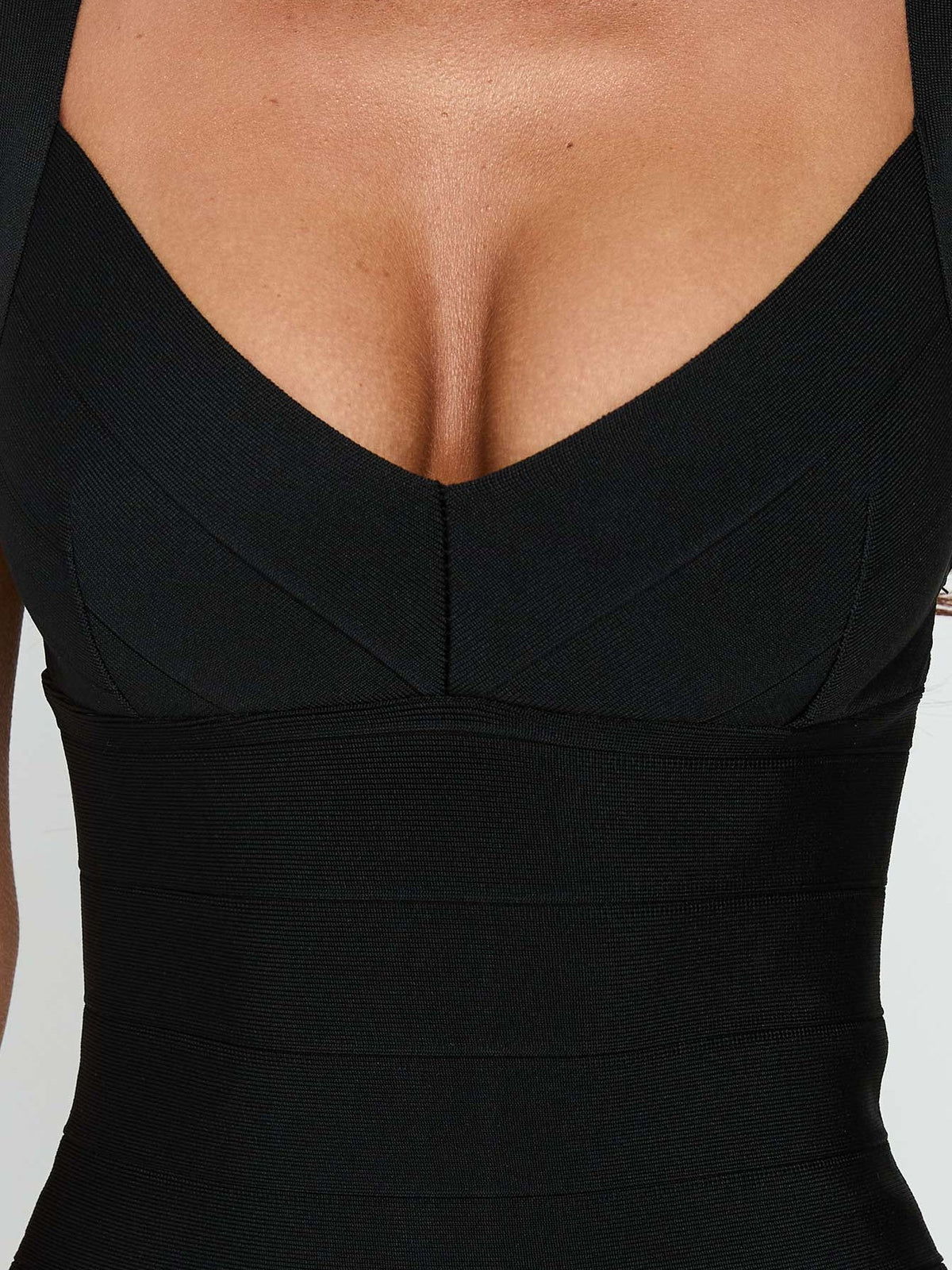 Black bandage midi dress close-up: V-shaped back neckline and fitted seam detailing.
