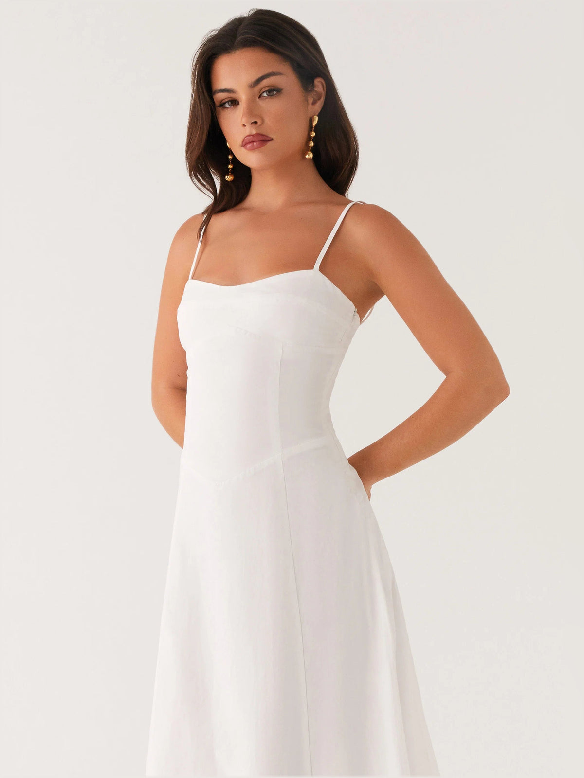 White midi formal dress close-up with spaghetti straps and fitted bodice