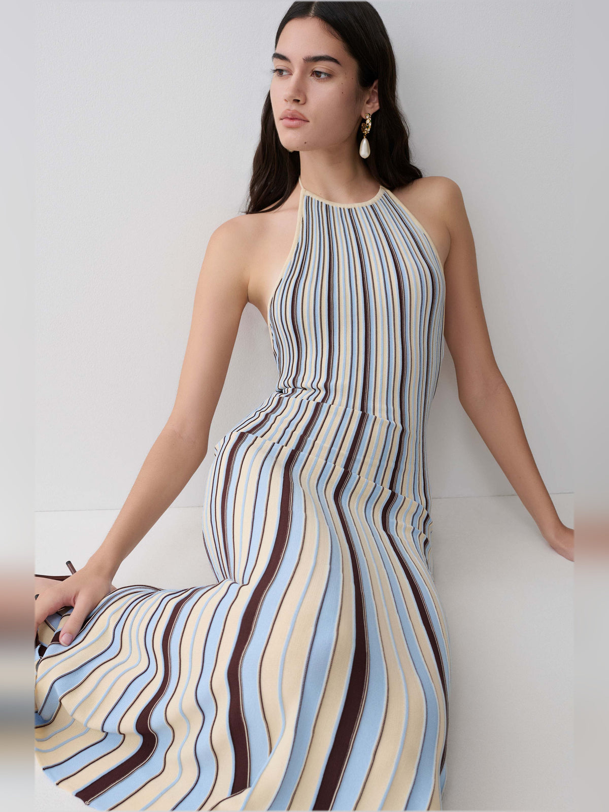 Halterneck knit midi dress detail with vertical cream, blue, and brown stripes and gathered skirt.