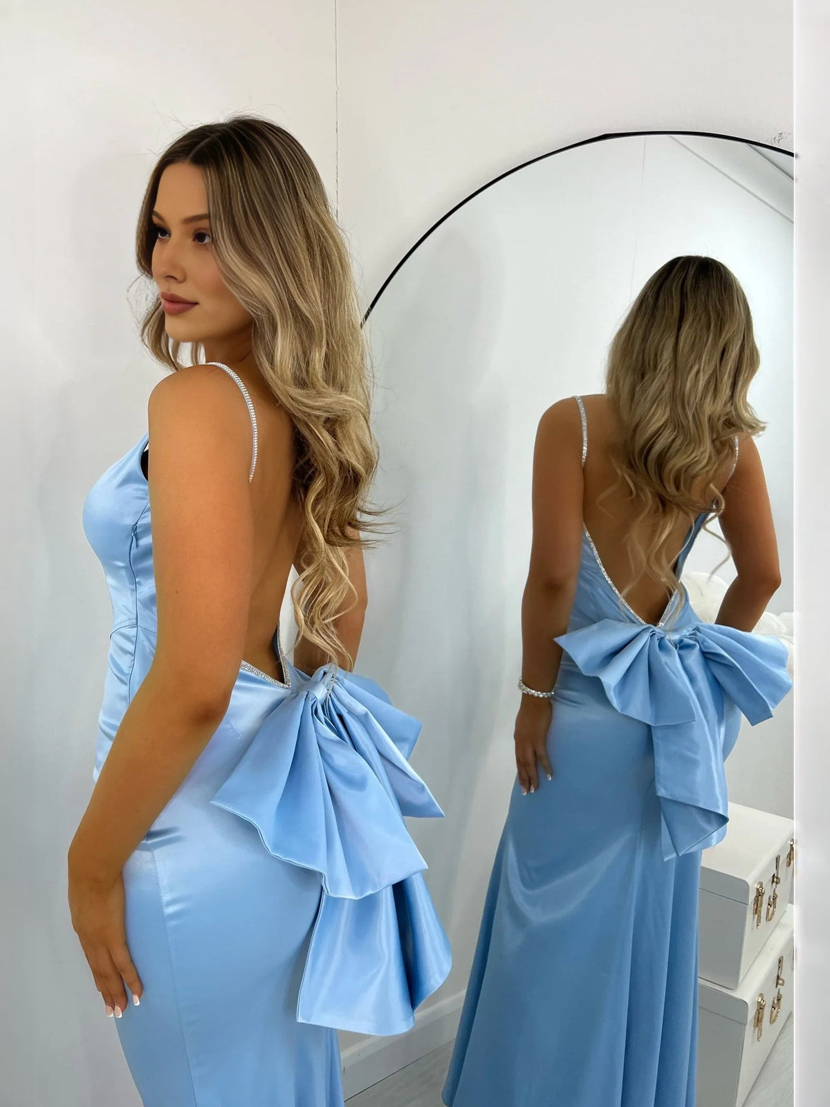 Light blue satin prom dress with backless cut and bow detail at the lower back