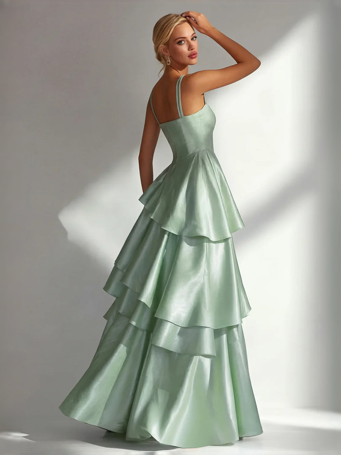 Dusty sage satin prom dress with square neckline, thin straps, and layered ruffle A-line hem.