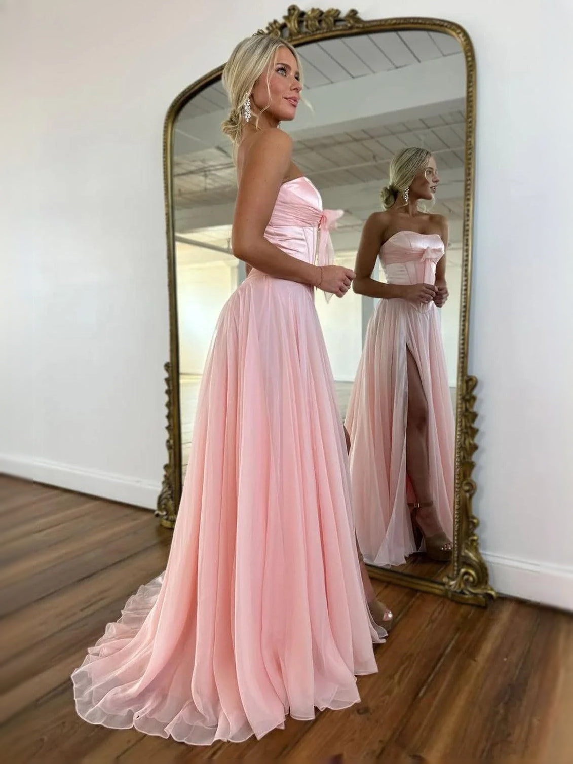 Blush pink strapless corset A-line prom dress with bow bodice and flowing chiffon skirt