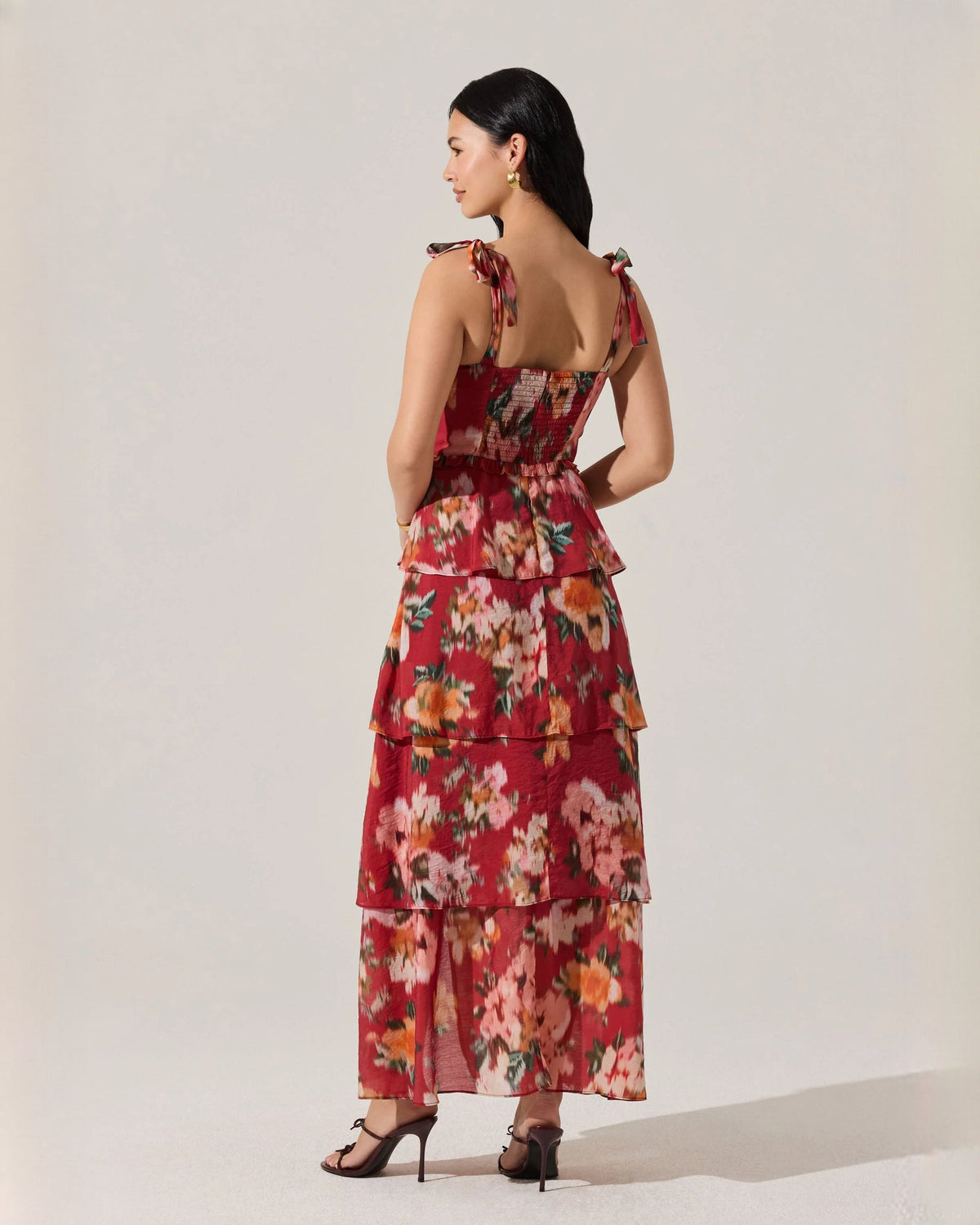 Red floral tiered maxi dress with open back and layered skirt tiers; bow tie straps