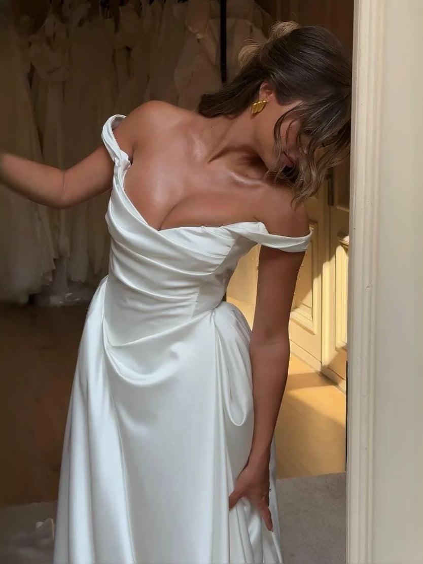 Ivory satin back view of a draped corset A-line wedding dress with off-shoulder cowl top