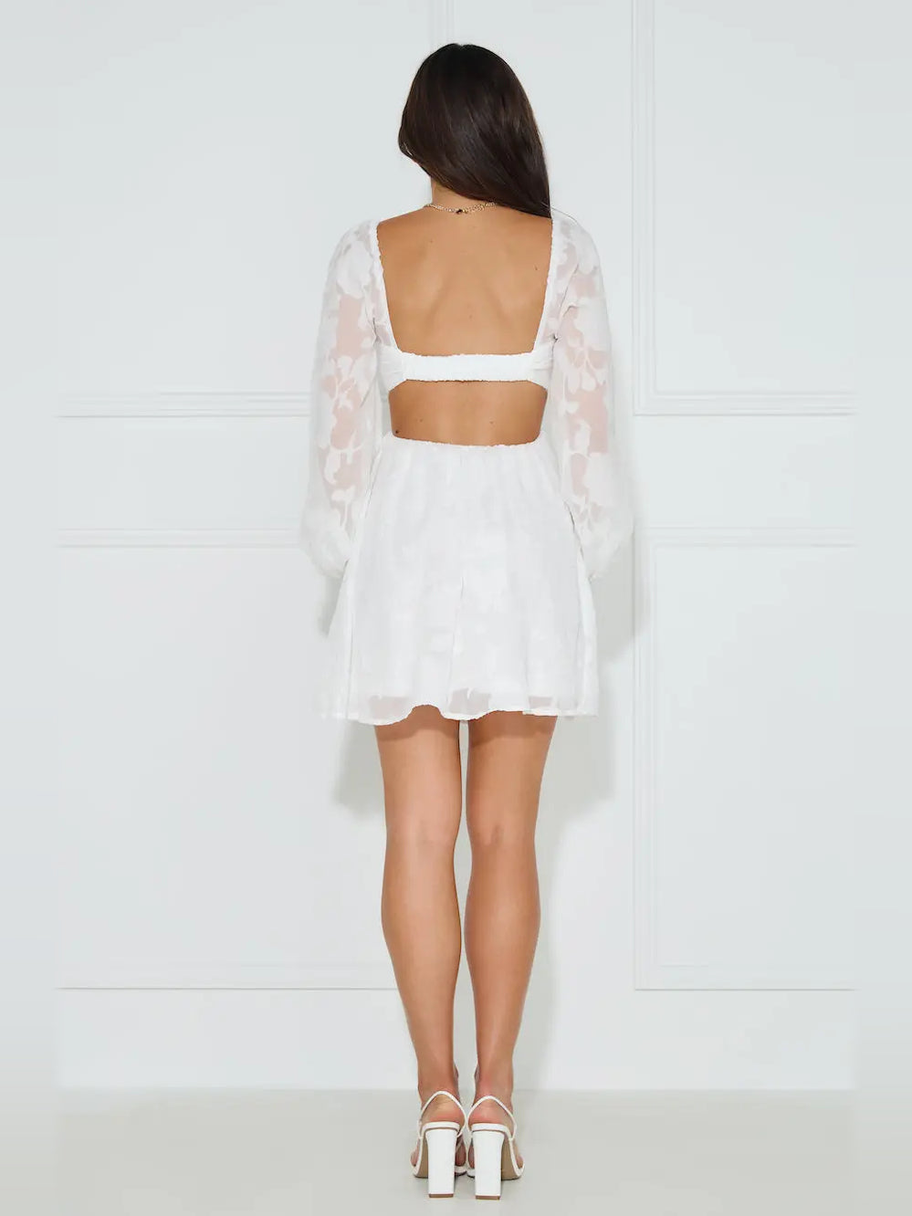 White mini dress back view with open square back and sheer long sleeves