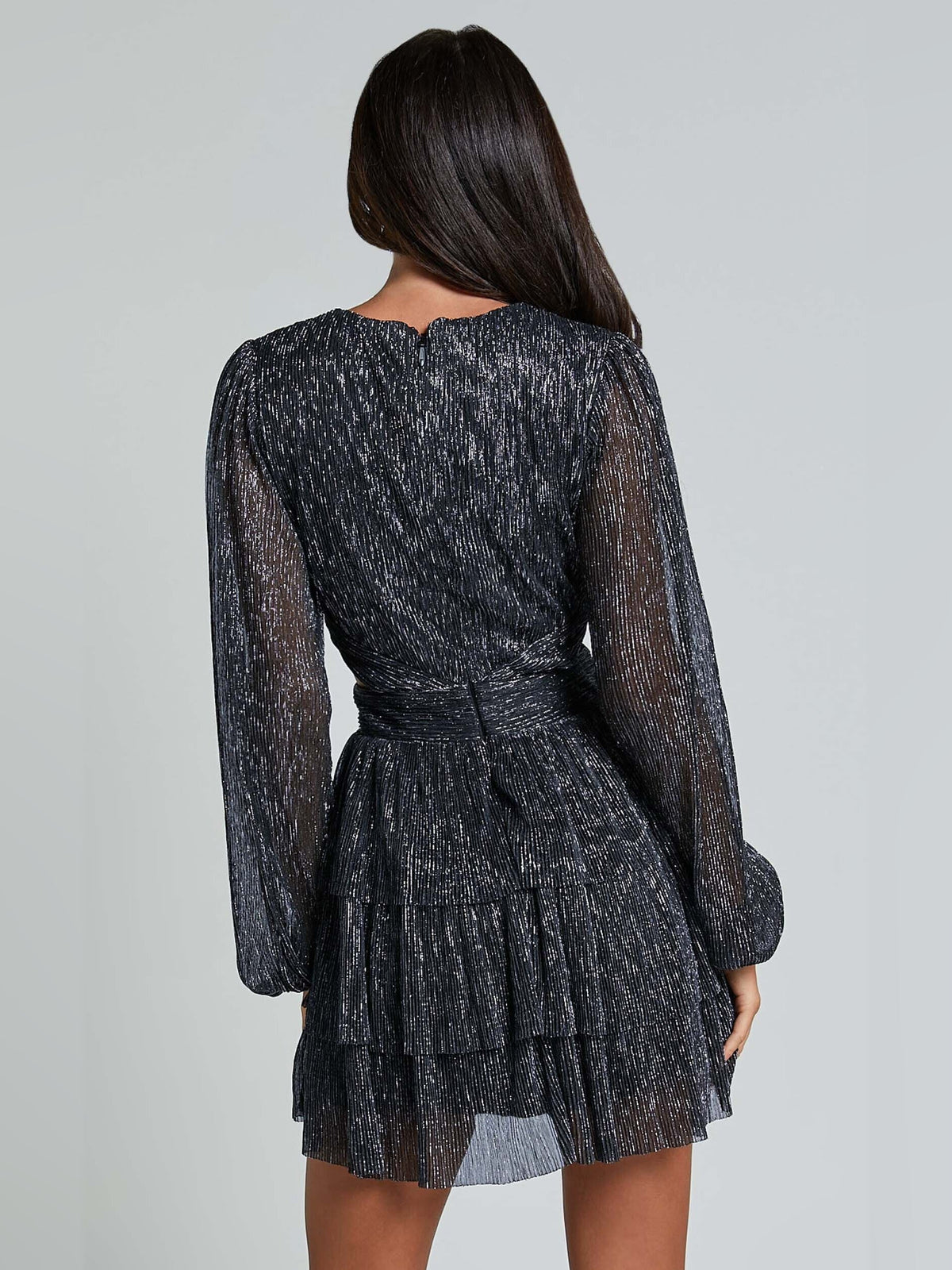 Black long-sleeve mini dress with V-neck back, tied waist, and tiered skirt