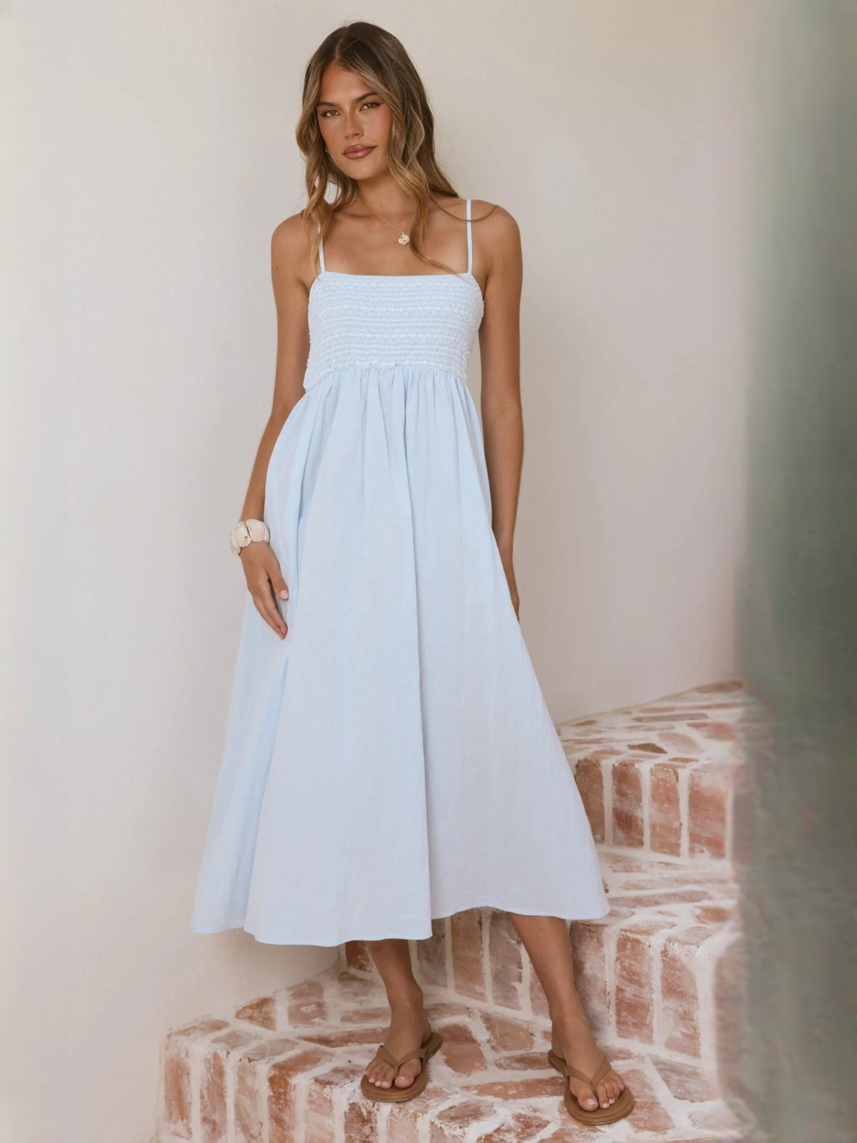 Light blue midi dress with smocked waist bodice and flowing gathered skirt