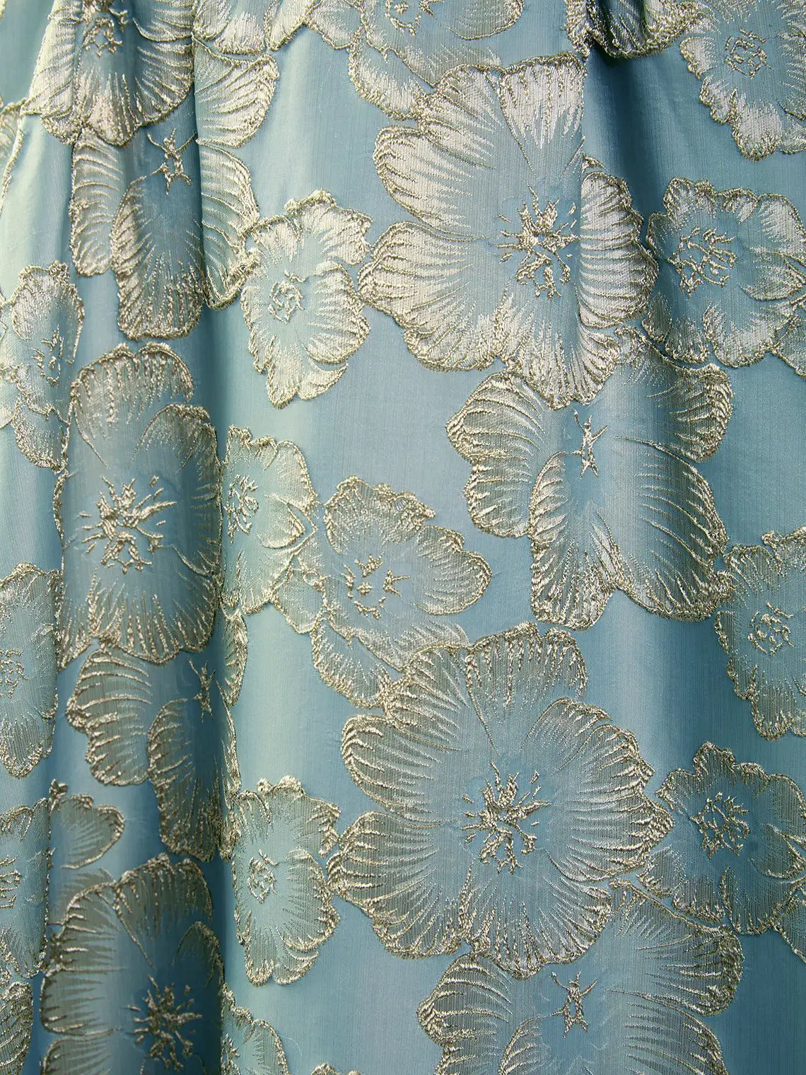 Close-up of blue formal dress fabric with gold embroidered floral pattern