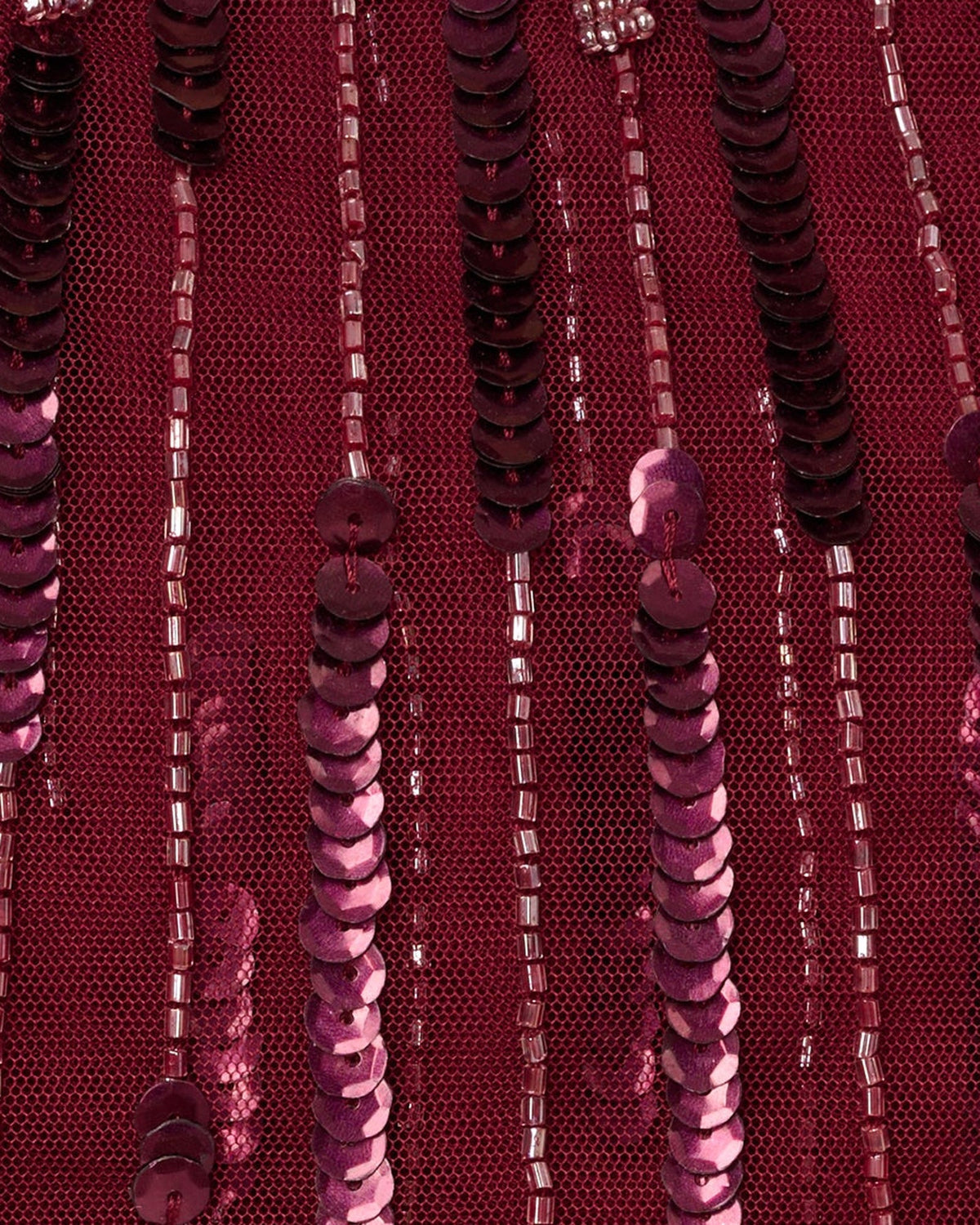 Close-up of burgundy sequins and beaded fringe strands on the dress surface