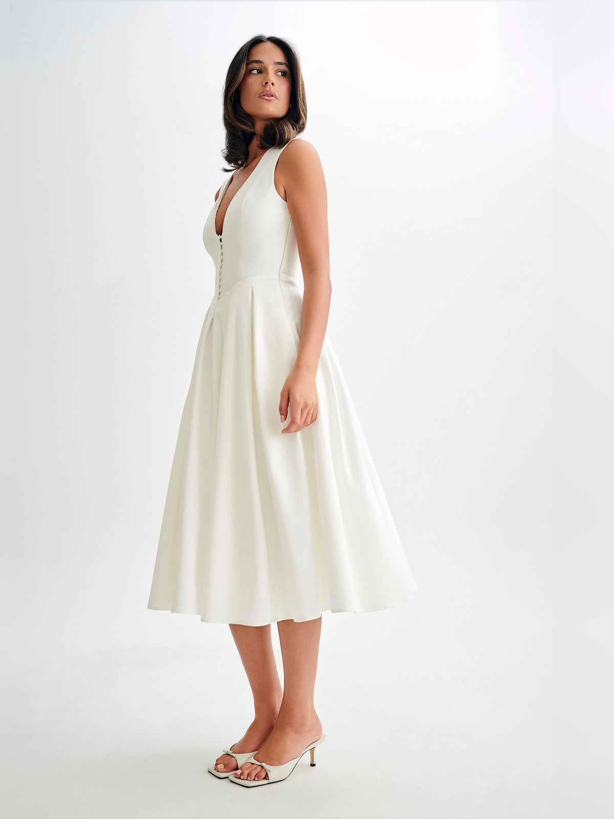 White sleeveless midi dress with V-neck and gathered waist, side view