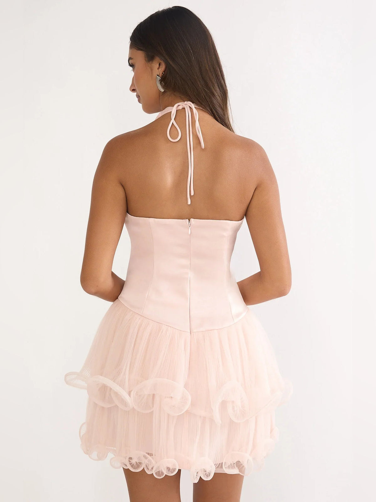 Blush pink corset-style mini dress with halter tie-back and layered ruffle hem