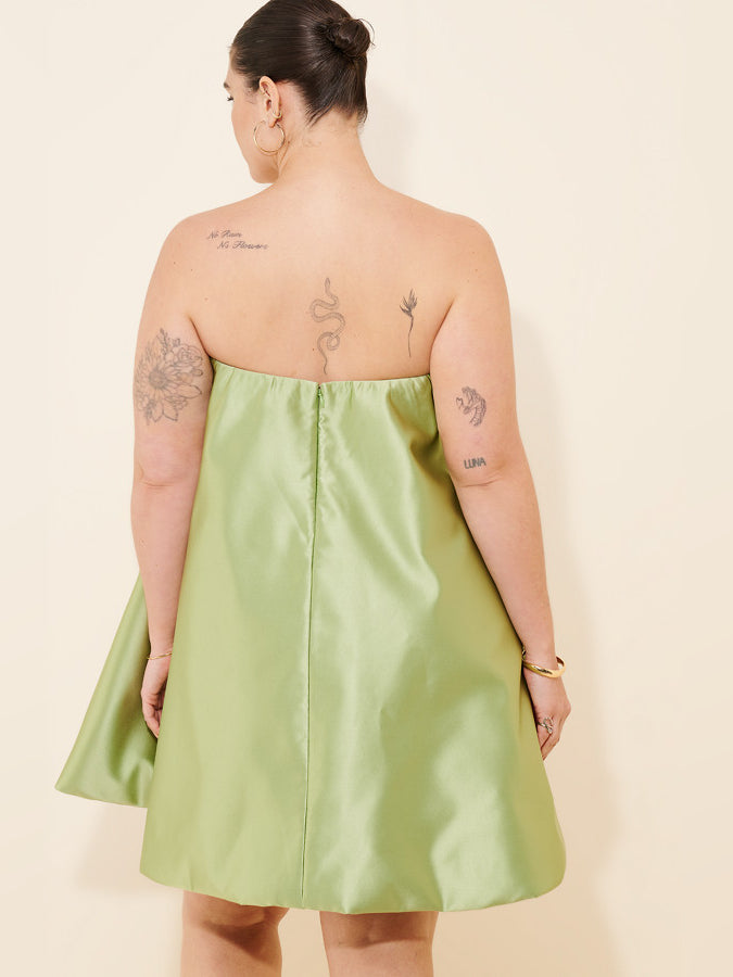Back view of lime green strapless mini dress with open back and center seam