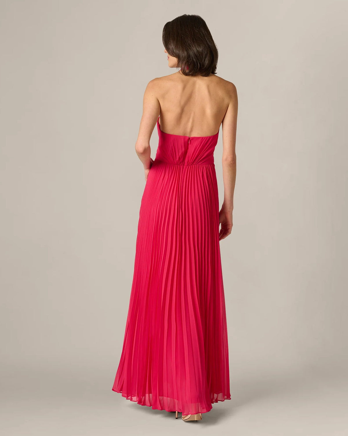 Back view of cherry red pleated halter maxi dress with open back