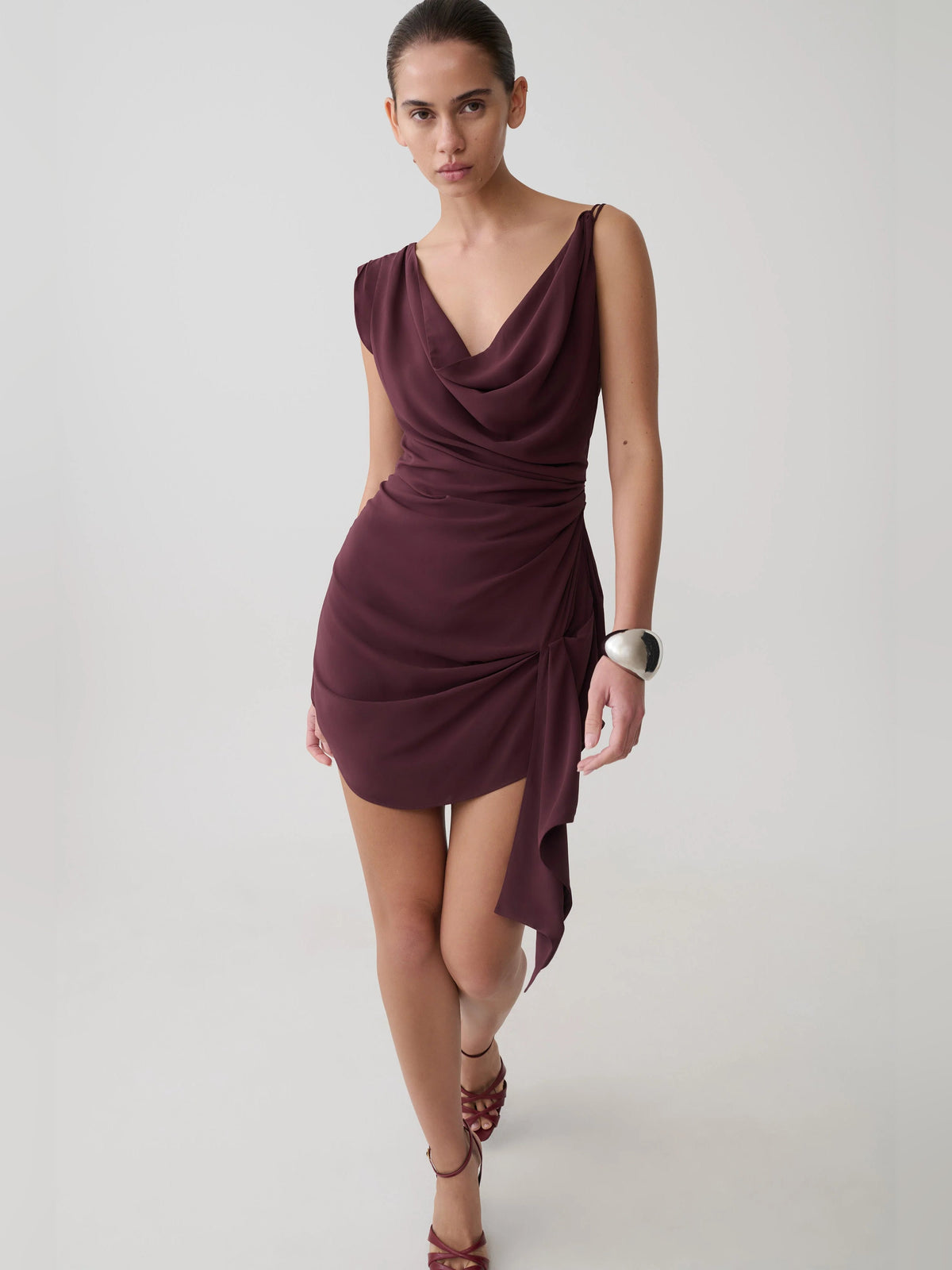 Plum satin mini dress with cowl neckline and cascading draped side panel
