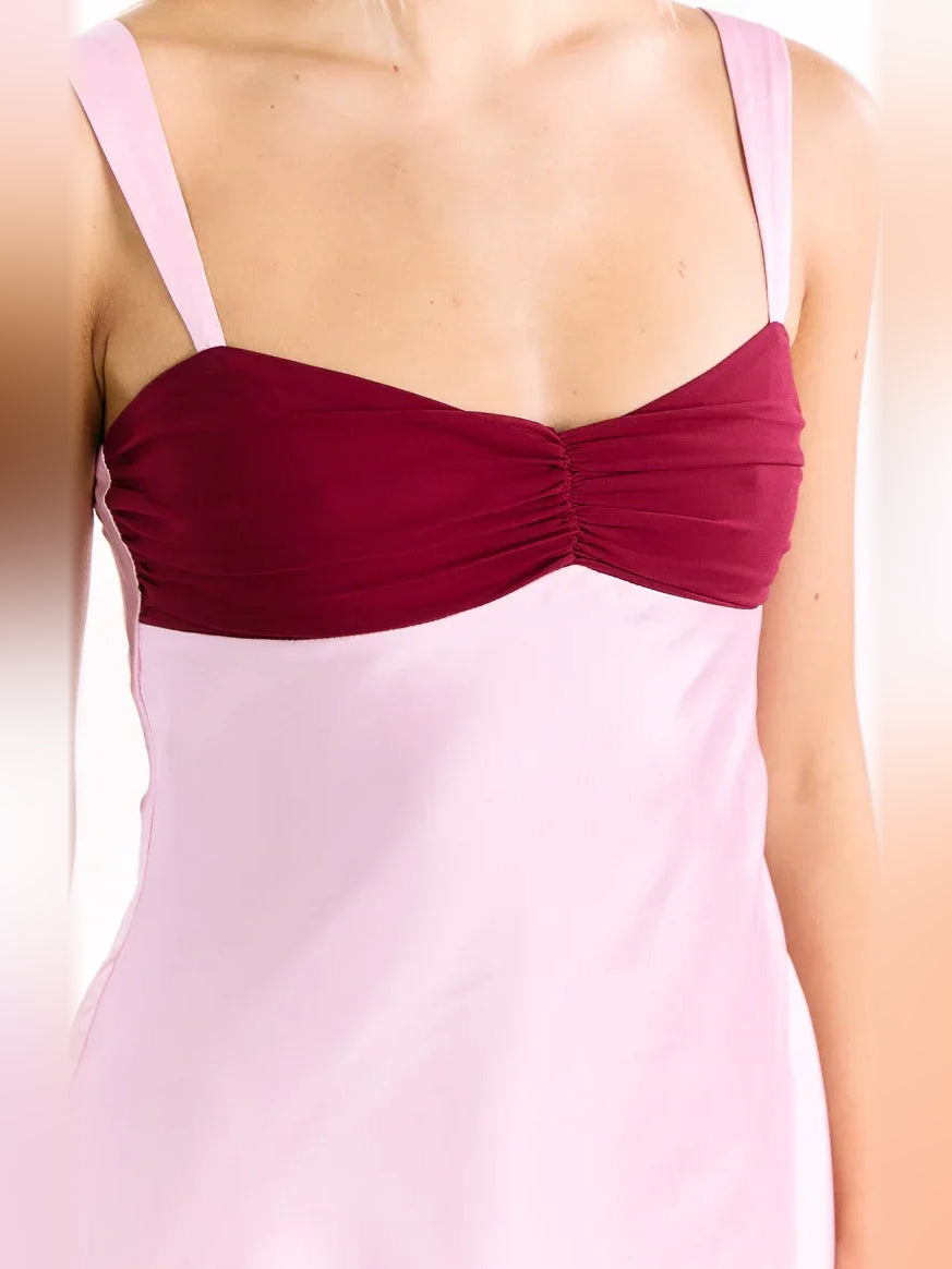 Ruched burgundy sweetheart bodice on light pink satin mini dress, spaghetti straps close-up