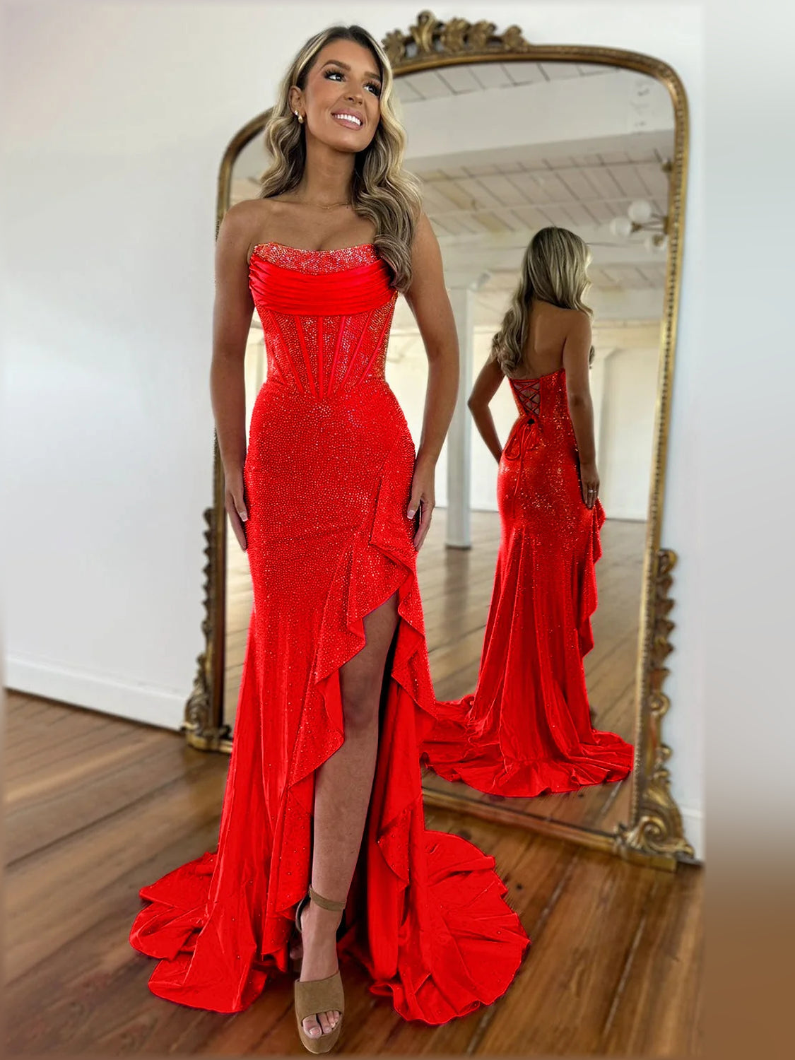 Red strapless mermaid formal dress with sparkling fabric and front leg slit.
