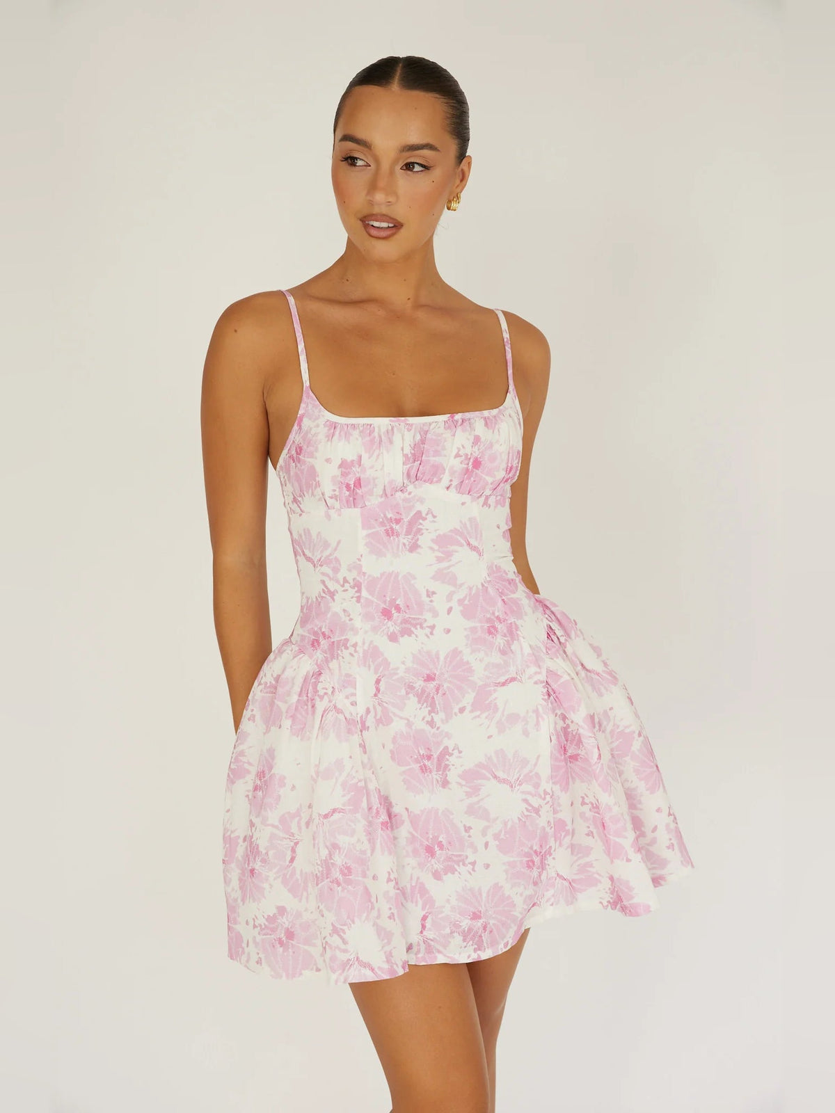 Pink floral mini dress with spaghetti straps and flared skirt, fitted bodice