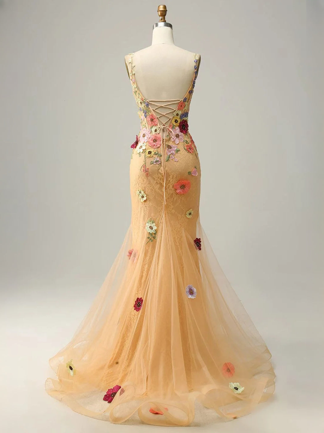 Peach tulle mermaid prom dress showing open-back corset detail and floral appliques
