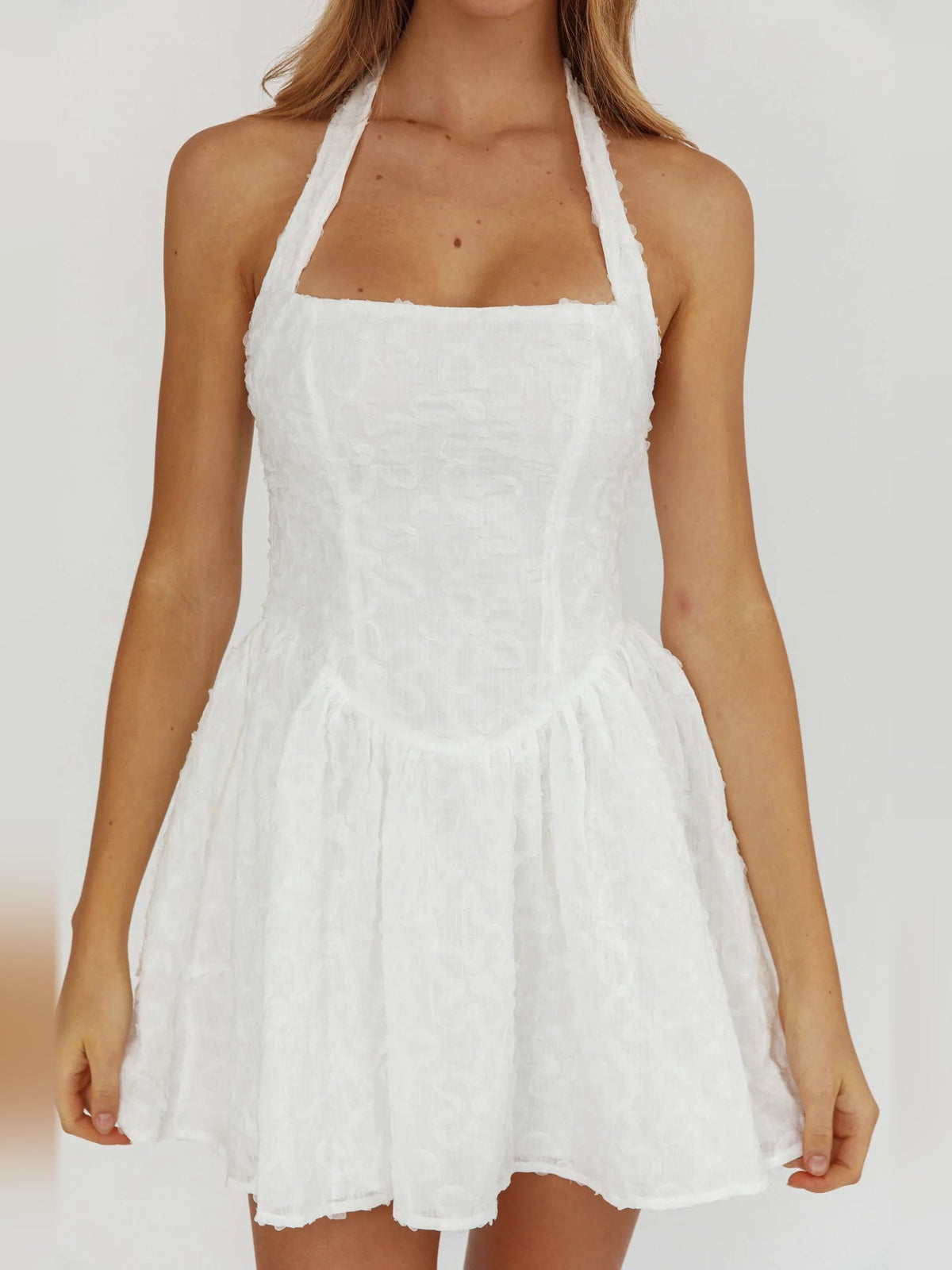 White halter neck mini dress with square neckline, textured bodice, flared tiered skirt