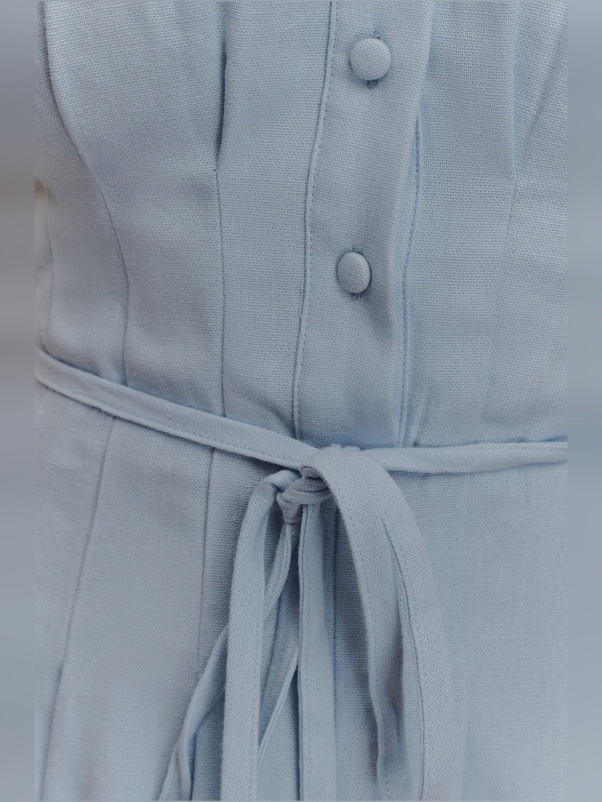 Cornflower blue linen dress close-up: button placket and tied waist drawstring