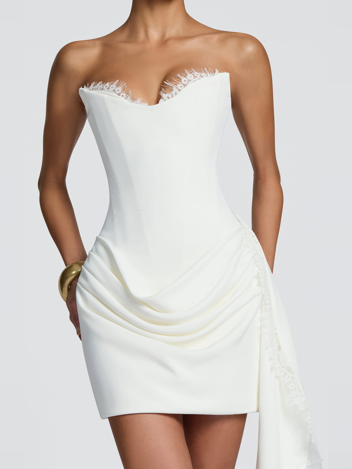 Ivory strapless mini dress with corset seams, draped ruching, and lace-trim sash