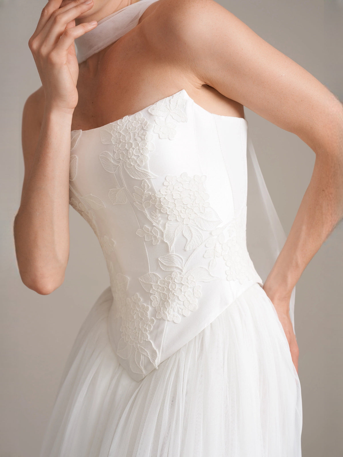 Ivory strapless corset with floral texture and draped detail at bodice