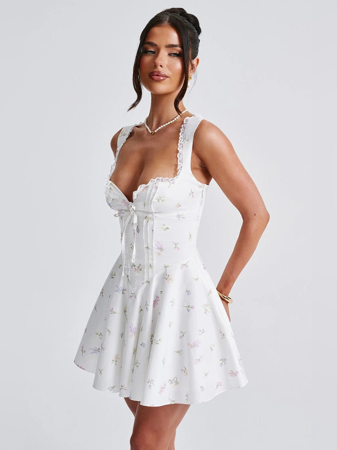 White floral mini homecoming dress with lace shoulder straps, corset seams and bow detail