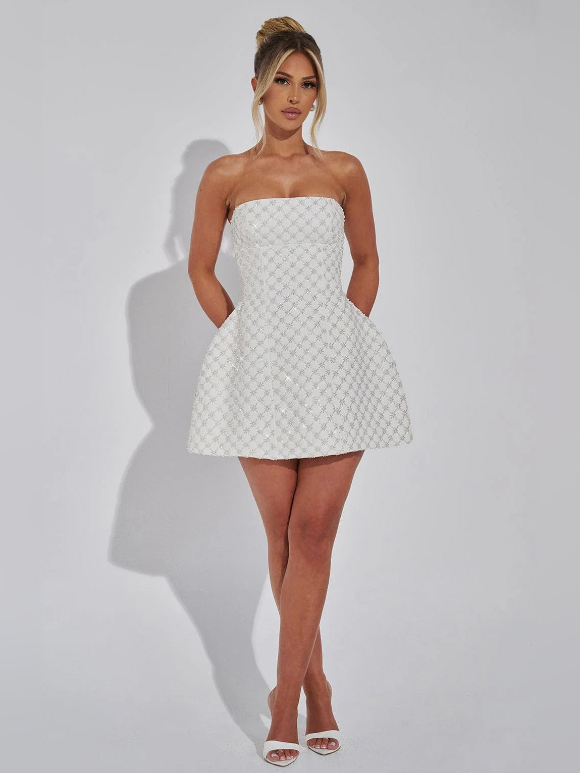 Ivory strapless mini dress on full-body view, textured fabric and flared skater skirt.