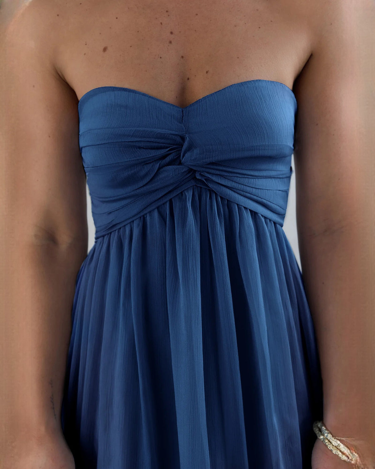 Close-up of navy strapless satin bodice with gathered knot detail