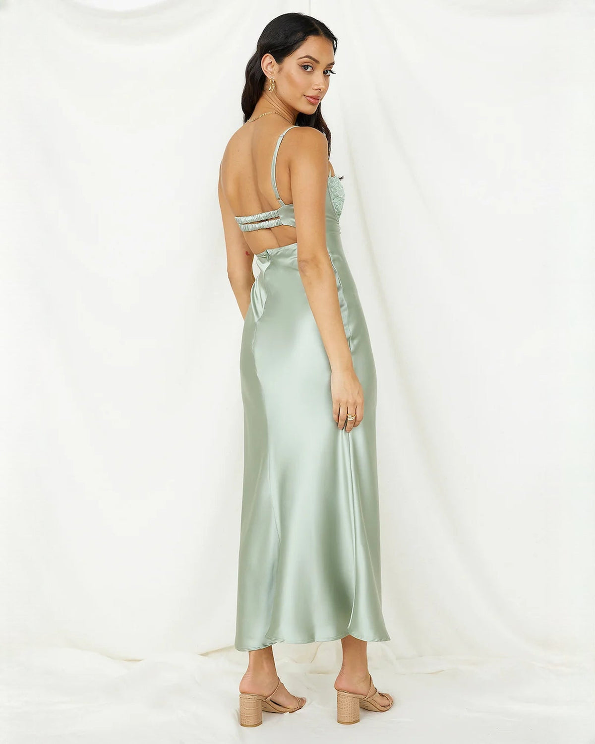Mint green satin midi dress viewed from the side with lace bust and back strap detail